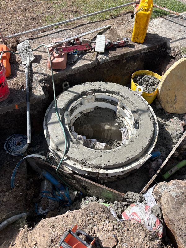Manhole riser being set in position